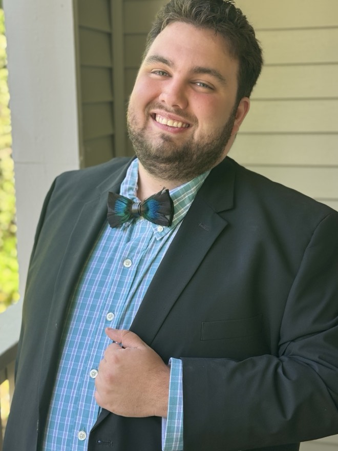 Bibby in a blazer and hand-tied bow tie on a porch
