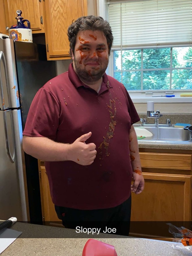 Bibby in a kitchen covered in sloppy joe, giving a thumbs up