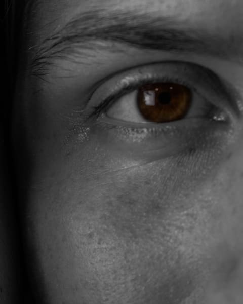 Extreme close-up of a single brown eye, the rest of the frame in black and white.